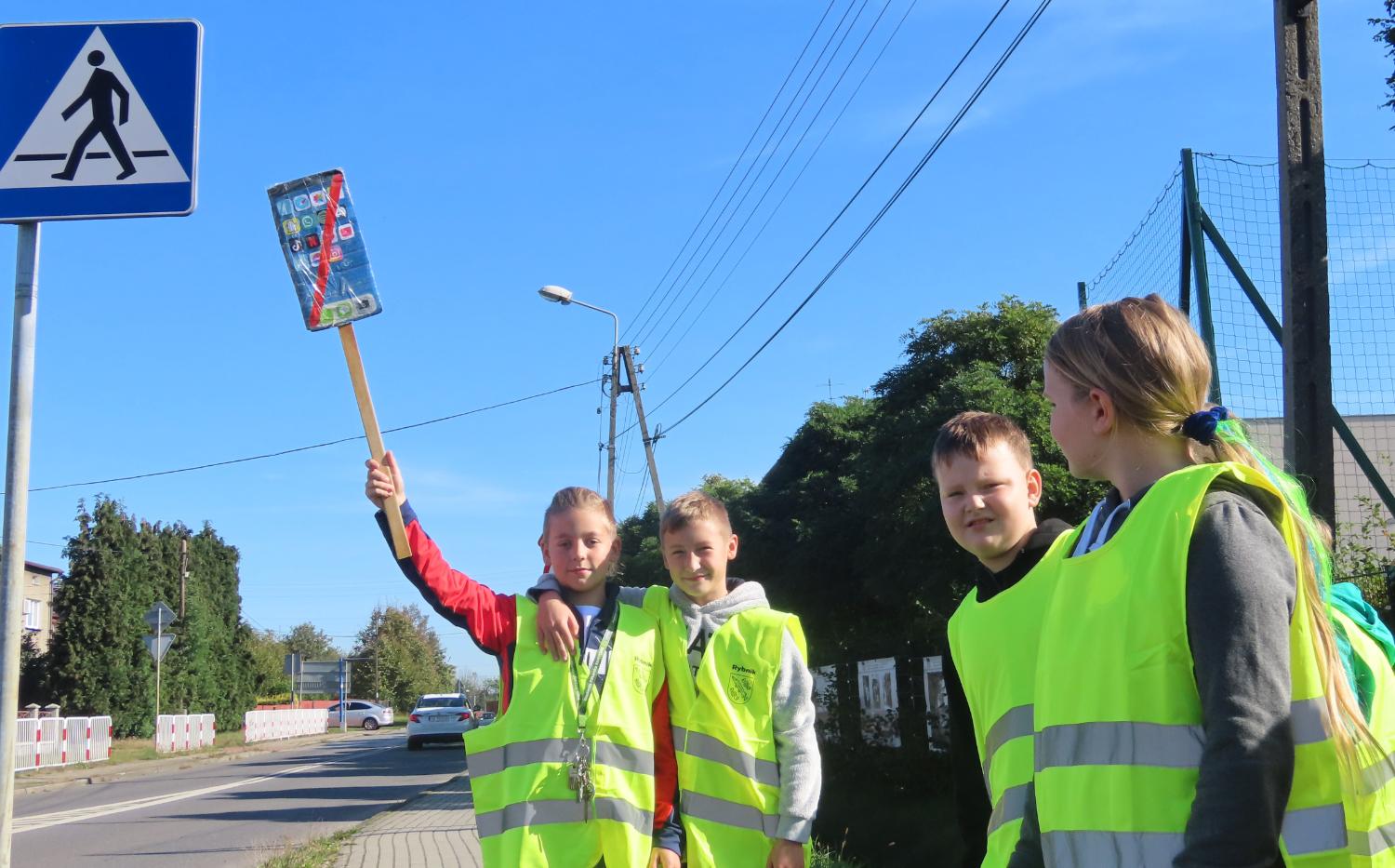 Odblaskowa szkoła w Kamieniu - uczniowie zachęcają przechodniów, aby zrezygnowali z używania telefonów na pasach. Zdj. SP nr 28